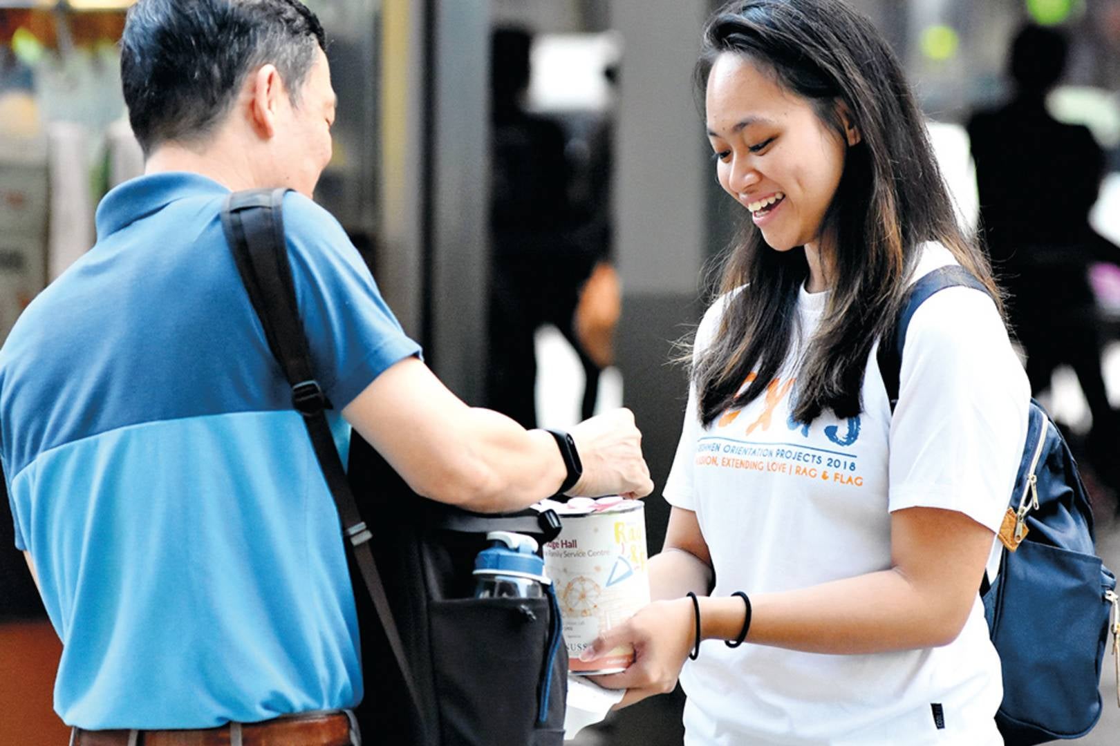 An NUS student collecting donations from the public on Flag Day.